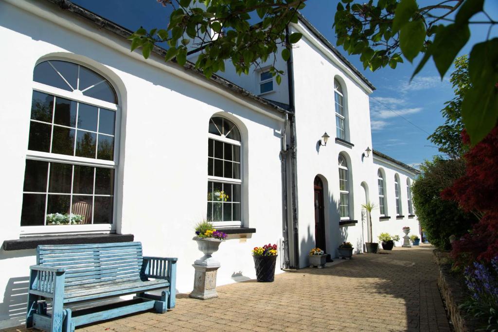 a white building with a blue bench in front of it at The Classroom, Patricks Square, Wexford Town in Wexford