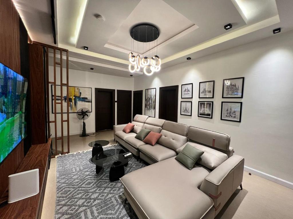 a living room with a couch and a flat screen tv at Blue Velvet Apartments II in Abuja