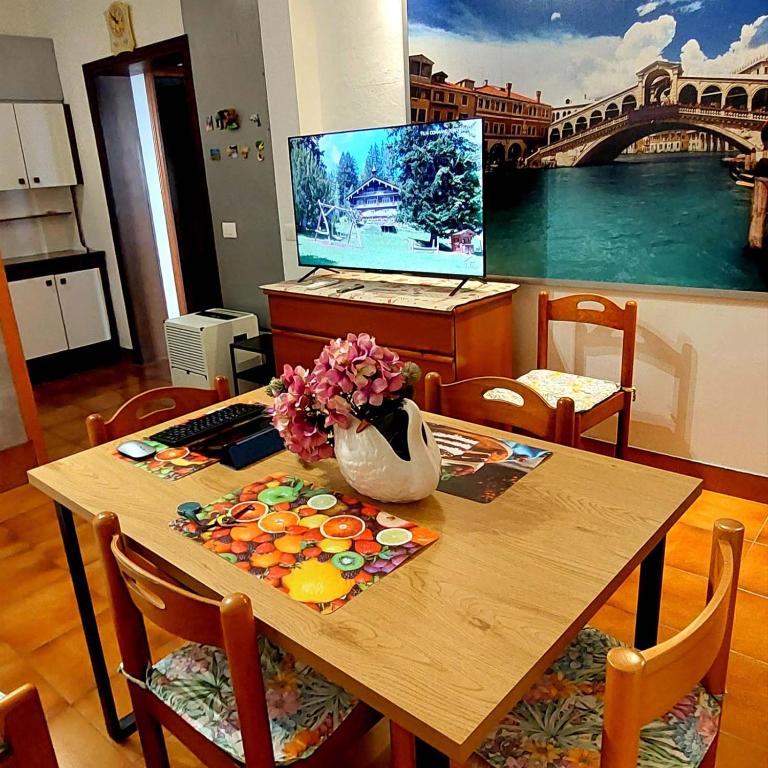 Una mesa de madera con un jarrón de flores encima. en Hotspot Venice EL FULVIA, en Carpenedo