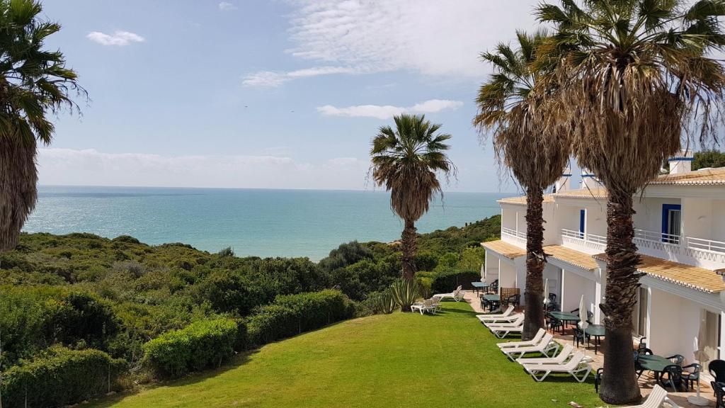 a view of the ocean from a house with palm trees at Pestana Palm Gardens in Carvoeiro