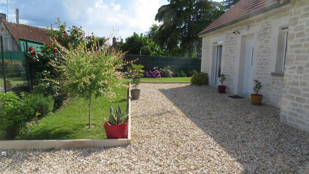 un jardin avec des plantes en pot et une maison dans l'établissement Gite en Sologne, -Châteaux de la Loire, Beauval -, à Millançay