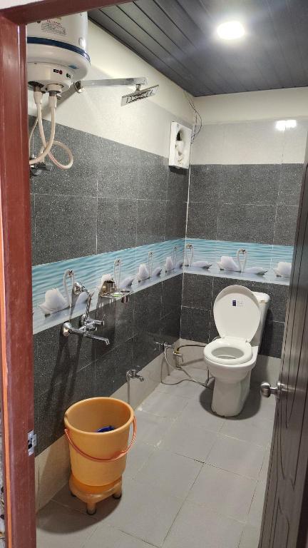 a bathroom with a toilet and faucet at Hotel your choice in Ukhimath
