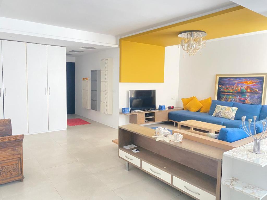 a living room with a blue couch and a tv at Modern & Spacious 2BR- Ville Haute Kenitra-Garage in Kenitra