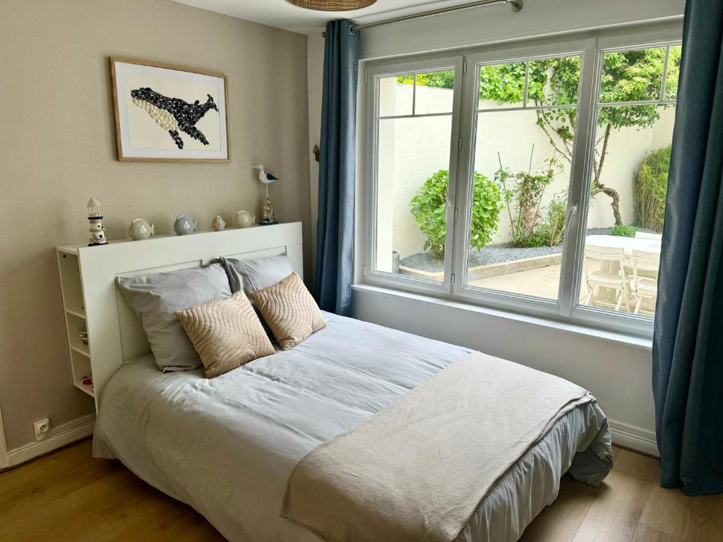 une chambre avec un lit et une grande fenêtre dans l'établissement La Petite Boulonnaise Studio cosy avec cour privative - proche Nausicaa, à Boulogne-sur-Mer