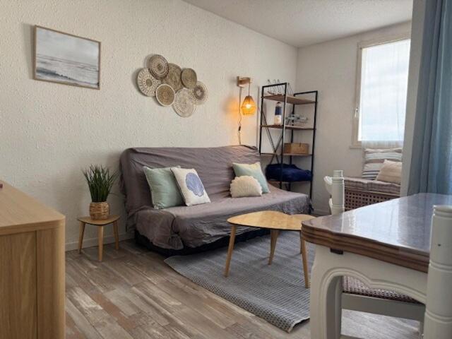 un salon avec un canapé et une table dans l'établissement Appartement plage des mouettes, à Saint-Hilaire-de-Riez