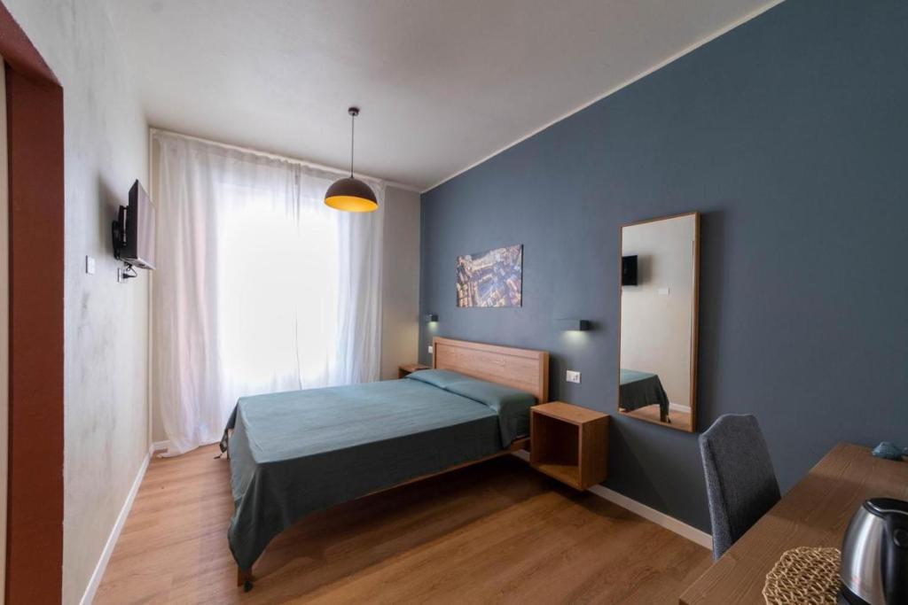 een slaapkamer met een bed en een spiegel bij A Due Passi dal Mare Stanza N2 in Porto Ercole