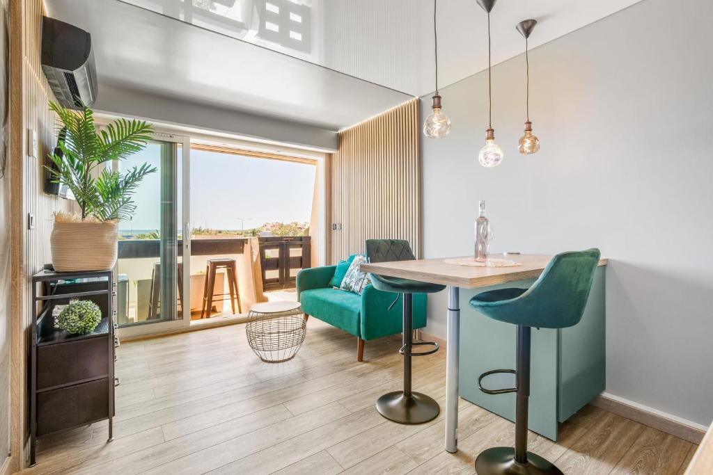 - un salon avec une table et des chaises vertes dans l'établissement Emeraude Port Nature, au Cap d'Agde