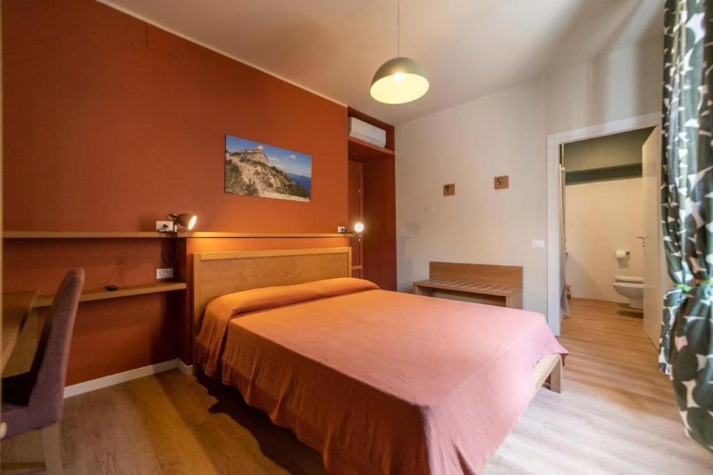 una camera da letto con un letto, una scrivania e un bagno di A Due Passi dal Mare Stanza N3 a Porto Ercole