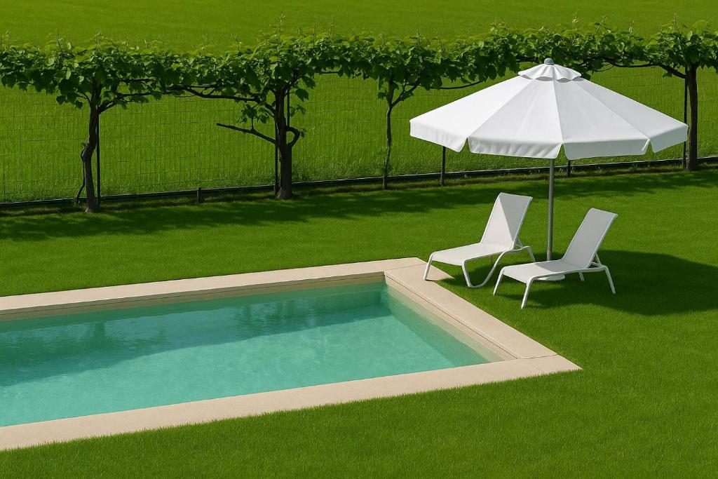 a swimming pool with an umbrella and two chairs at Villa Gemma in Alba