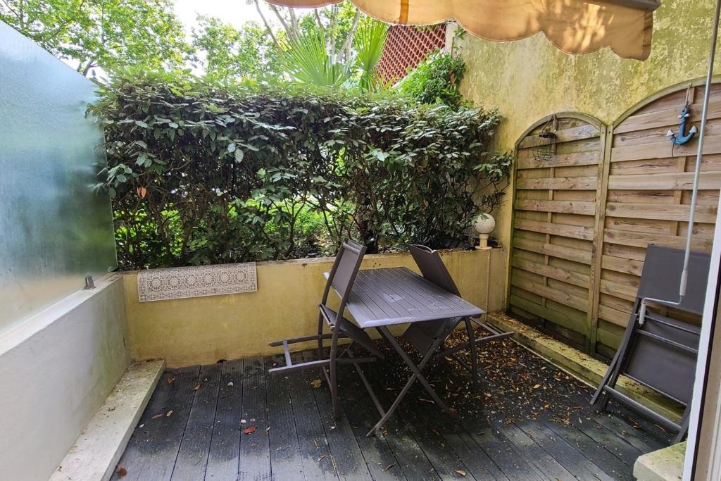 une table et des chaises en bois assises sur une terrasse dans l'établissement Nice studio with terrace near the beach, à Arcachon