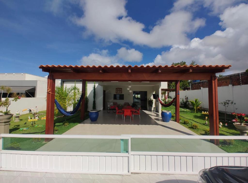 a patio with a pergola and a table at Casa Primavera aluguel temporada in Paripueira