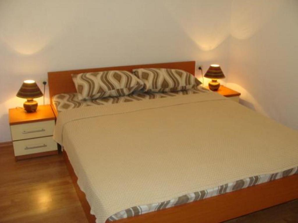 a bedroom with a large bed with two night stands at Apartments Krvavac in Klek