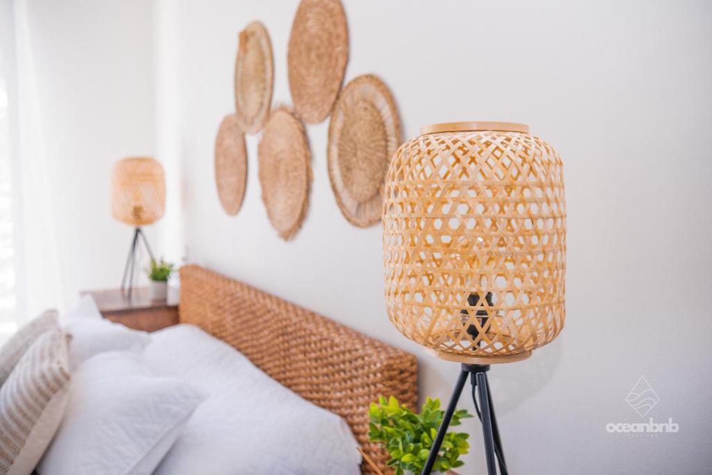 a living room with a rattan lamp and a couch at SantiChanti Walk to Sunzal Beach in Tamanique