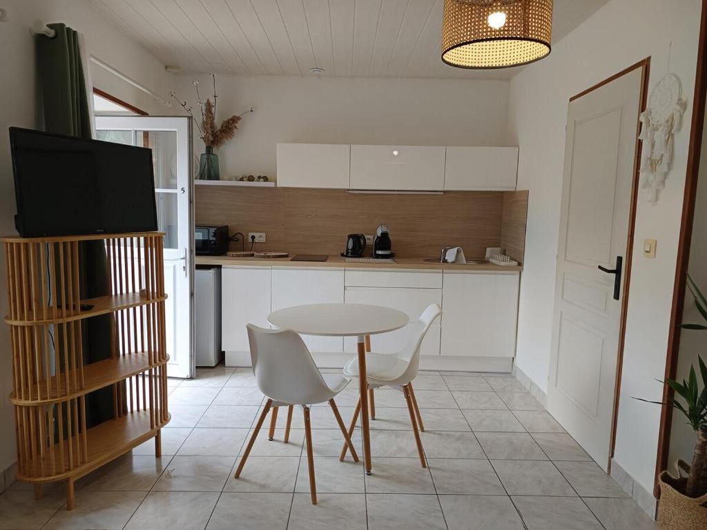 a kitchen with a table and chairs in a kitchen at Studio équipé, proche aéroport in Bouguenais