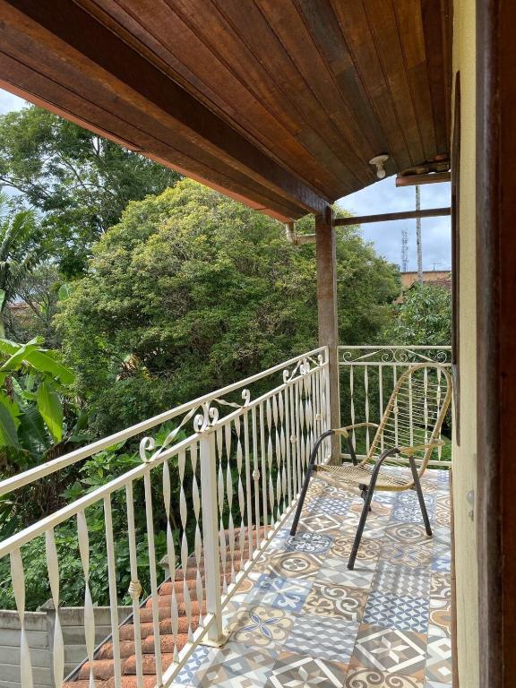 a porch with a chair on a balcony at Chalé Aconchego da Paz - Chalé 2 in Lavras Novas