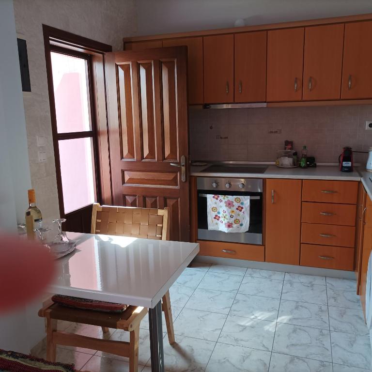 a kitchen with wooden cabinets and a table and a stove at Pedi Breeze in Symi