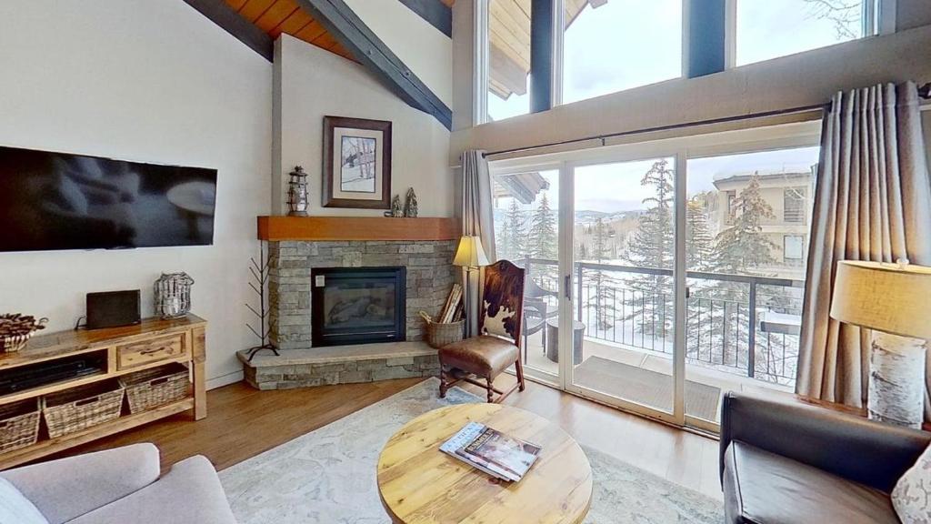 a living room with a table and a fireplace at Crestwood 3313 Deluxe 1 Bedroom Plus Loft in Snowmass Village