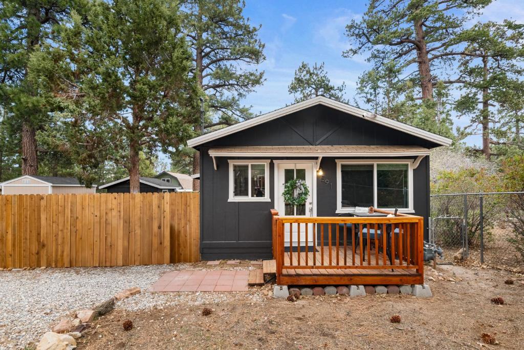 a small black house with a wooden fence at The Maple Lane Hideaway - Hot Tub, Fireplace, Barbecue, Fenced Yard! in Sugarloaf