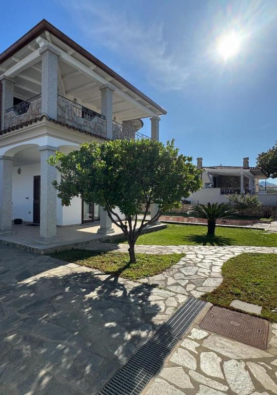 una casa blanca con un árbol delante en Federica's House, en Olbia