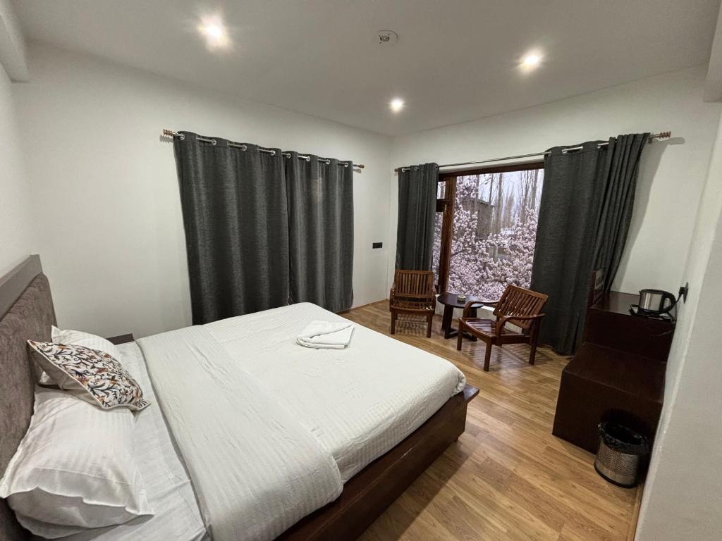 a bedroom with a bed and a large window at BARCHA Guest house in Leh