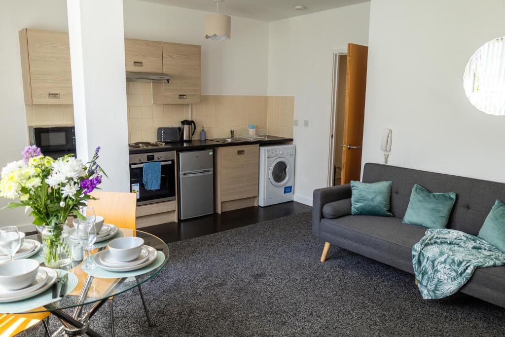 una sala de estar con un sofá y una mesa en The Trafford Luxe , Garage Parking, Self Check-in Anytime - Perfect for Late Arrivals, Ultra- Fast Wi-Fi, 5 mins to Old Trafford Stadium, en Mánchester