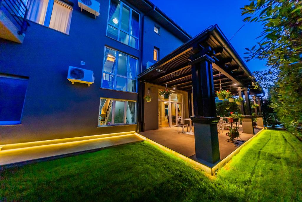 a house with a green lawn in front of it at Pensiunea Belanco in Arad