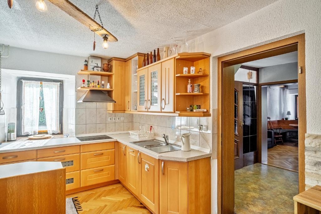 una cucina con armadi in legno e lavandino di Resort pod orehi - Bled - Apartma & Glamping & Savna a Bled