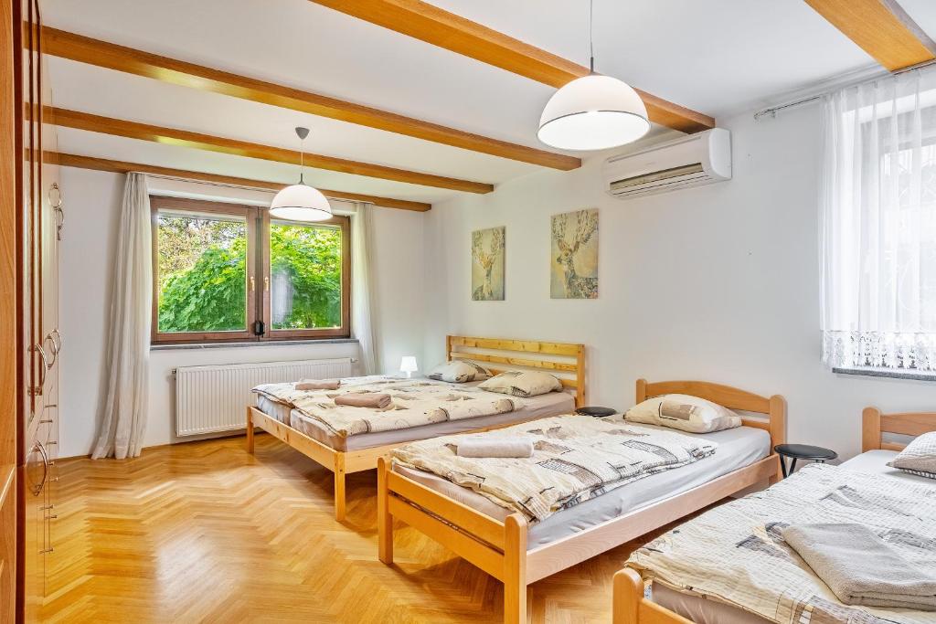 una camera da letto con tre letti e una finestra di Resort pod orehi - Bled - Apartma & Glamping & Savna a Bled