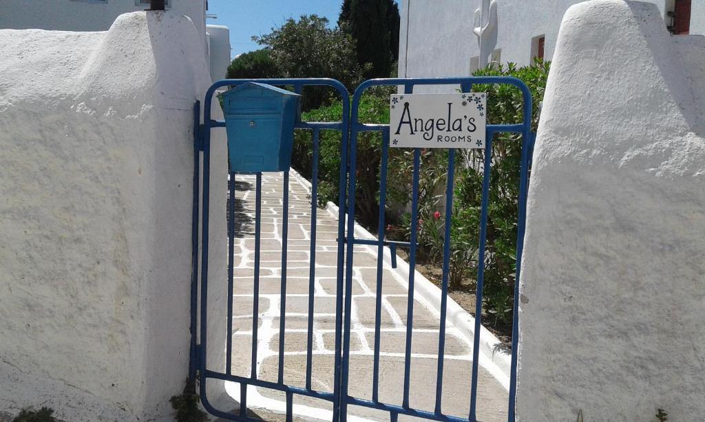 a gate with a sign on the side of a building at Angela's Rooms in Mikonos