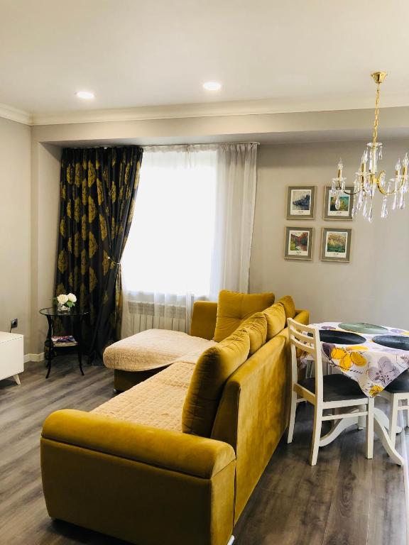 un salon avec un canapé et une table dans l'établissement Светлая квартира в центре, à Almaty