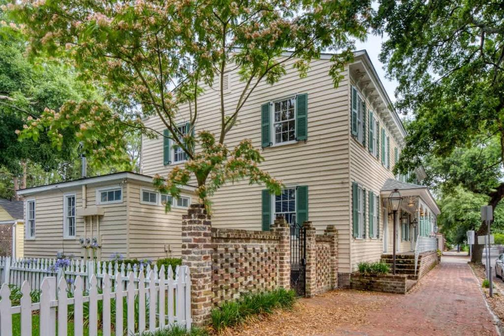 a white house with a white fence in front of it at Updated Historic Villa 3 BR suites Walk Everywhere in Savannah
