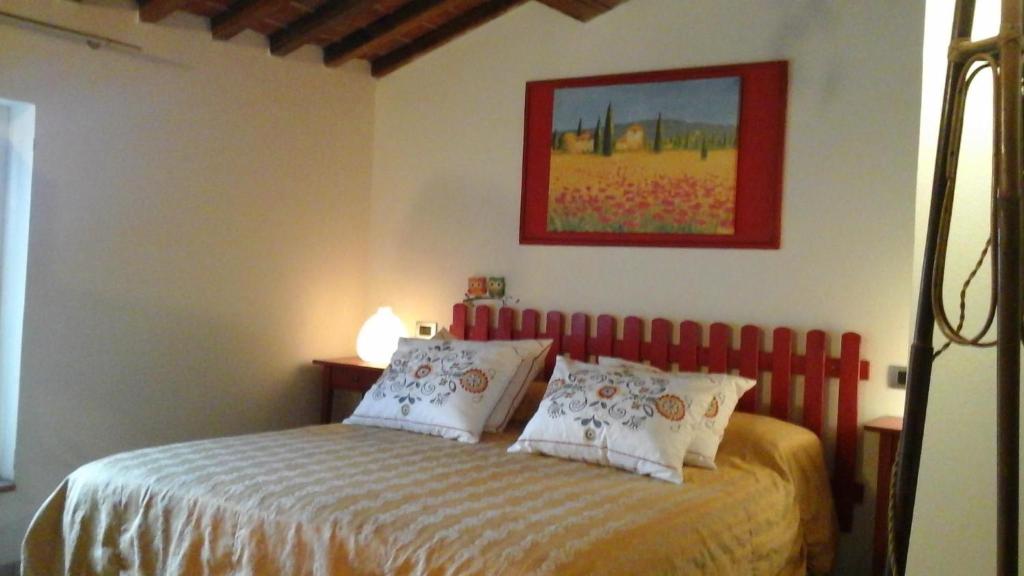 a bedroom with a bed with a red head board at Penelope in Marliana