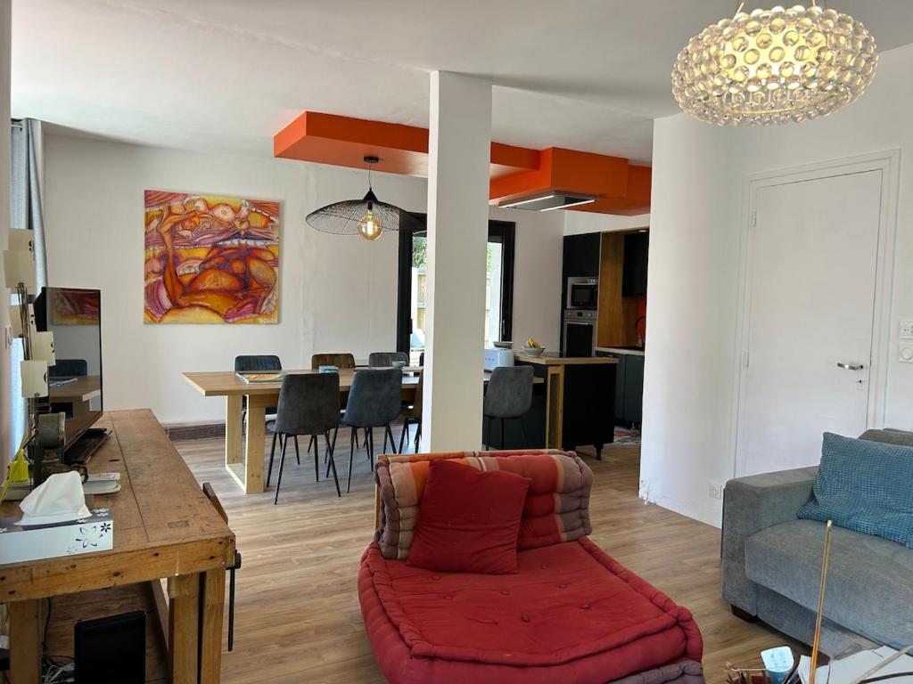 - un salon avec un canapé et un fauteuil rouge dans l'établissement Maison charmante avec piscine, à Andernos-les-Bains