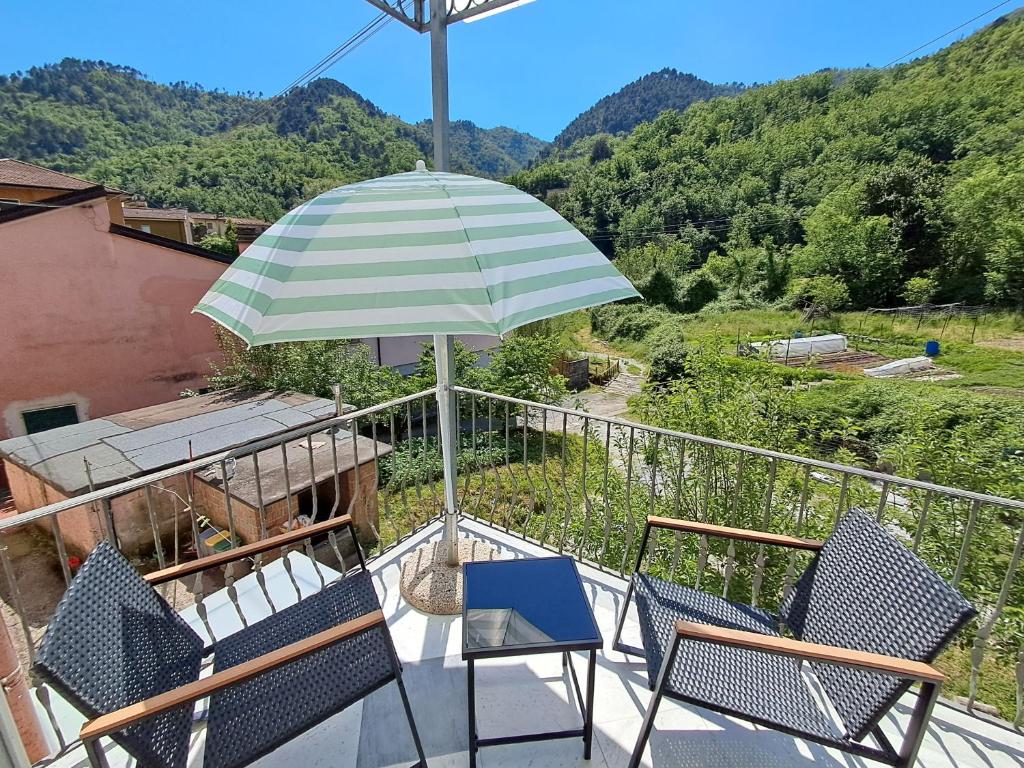 a patio with two chairs and an umbrella at Casa Mariarosa Tuscany in Gragnana