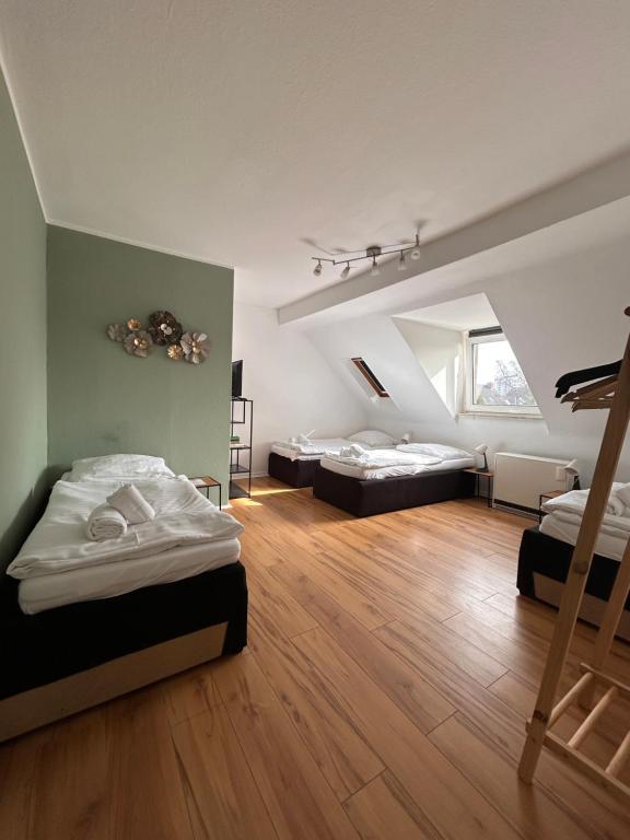 a large room with two beds and a staircase at Apartmenthaus Essen Rüttenscheid in Essen