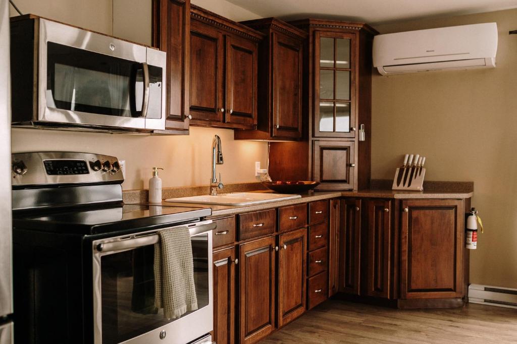 a kitchen with wooden cabinets and stainless steel appliances at Albert's in Shelburne