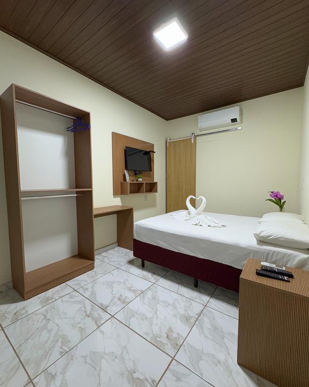 a room with a bed and a tv in it at Suítes no centro de Bonito, Bonito Brasil Turismo in Bonito