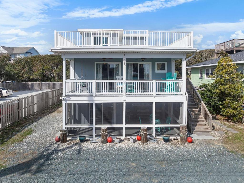 a white house with a balcony on top of it at The Iron Seahorse Orlop Surf City Condo in Surf City