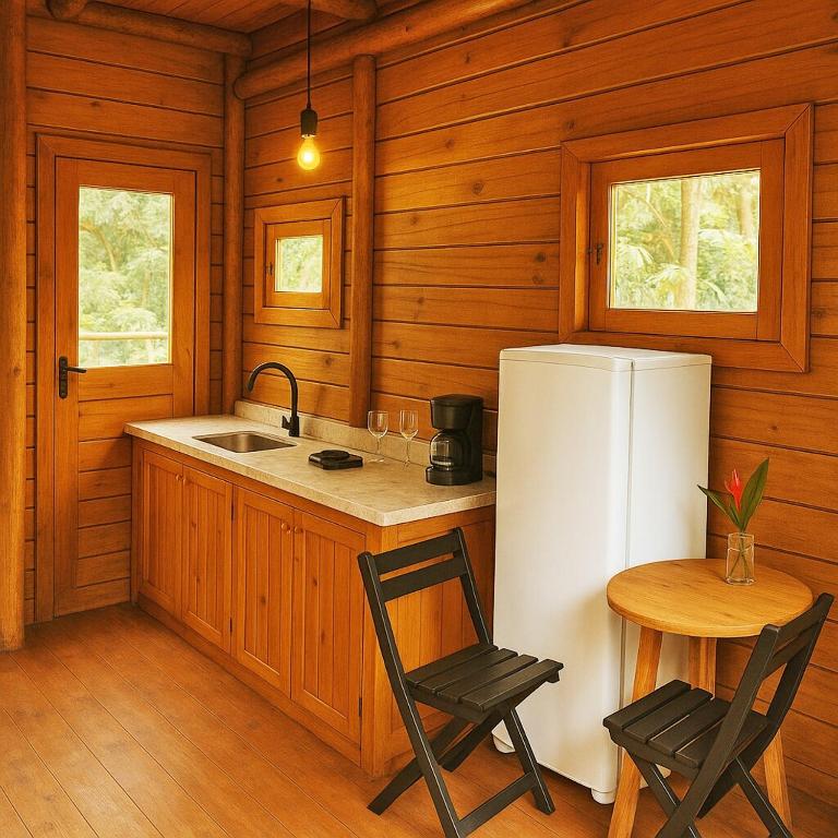 a kitchen with a refrigerator and a table and chairs at Natural Harmony Bungalow in Baturité