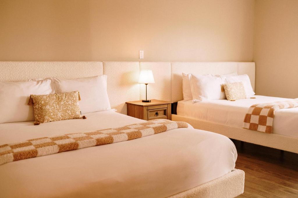 a hotel room with two beds and a lamp at Albert's in Shelburne