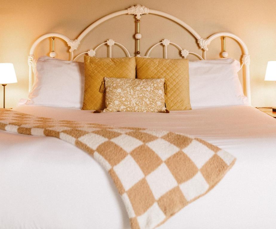 a bedroom with a bed with yellow and white pillows at Albert's in Shelburne