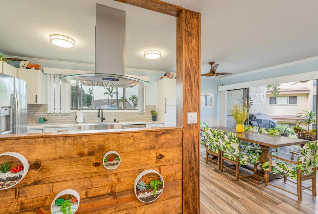 une cuisine et une salle à manger avec un mur en bois dans l'établissement Big Island Keauhou Punahele C104 by Coldwell Banker Island Vacations, à Kailua-Kona