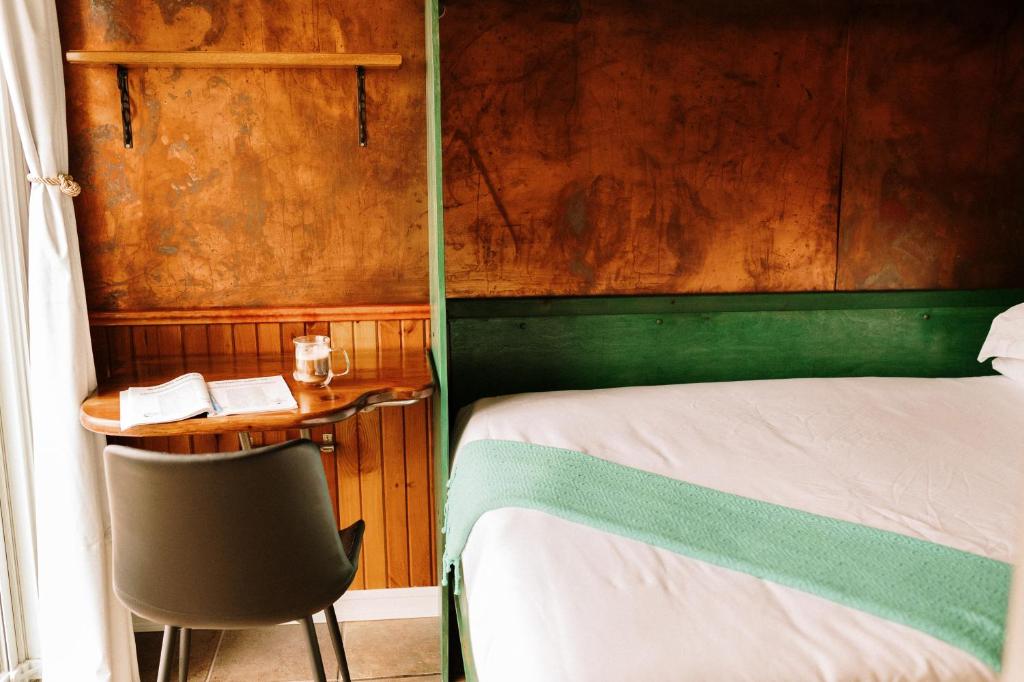 a bedroom with a bed and a desk with a chair at Albert's in Shelburne