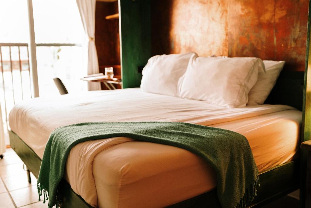 a bed with a green blanket on top of it at Albert's in Shelburne