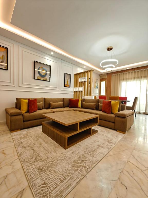 a living room with a couch and a coffee table at Appart Moderne Vue mer latérale & piscine - Plage des Sablettes El Mansouria in Ben Slimane