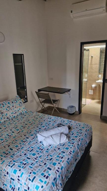 a bedroom with a bed with a blue and white comforter at Mini Aptoestudio para 2 personas in Cúcuta