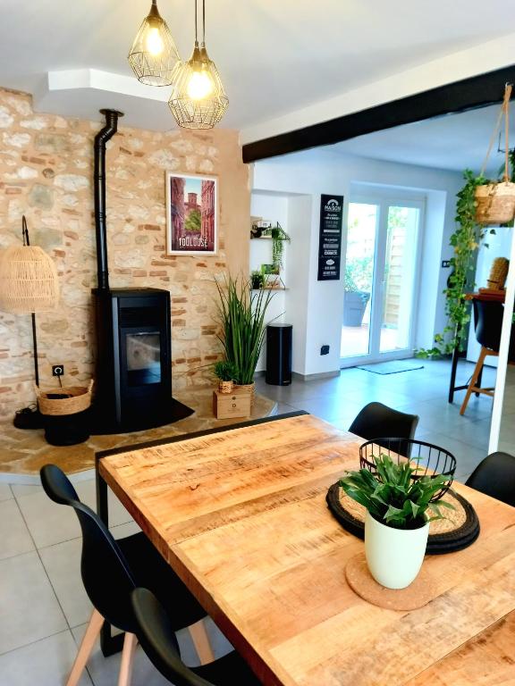 une salle à manger avec une table en bois et une cheminée dans l'établissement Gîte Abelia avec extérieur, à Lavaur