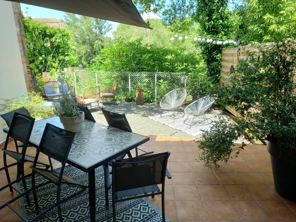 a patio with a table and chairs on a patio at Gîte de charme Abelia avec extérieur au calme in Lavaur