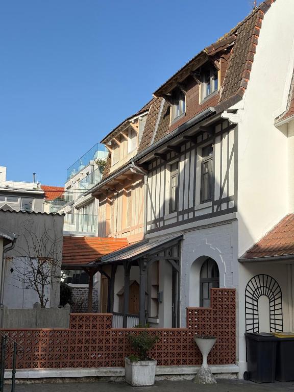 un bâtiment avec une clôture devant lui dans l'établissement Villa Touquettoise - 200m de la mer et commerces, à Le Touquet-Paris-Plage