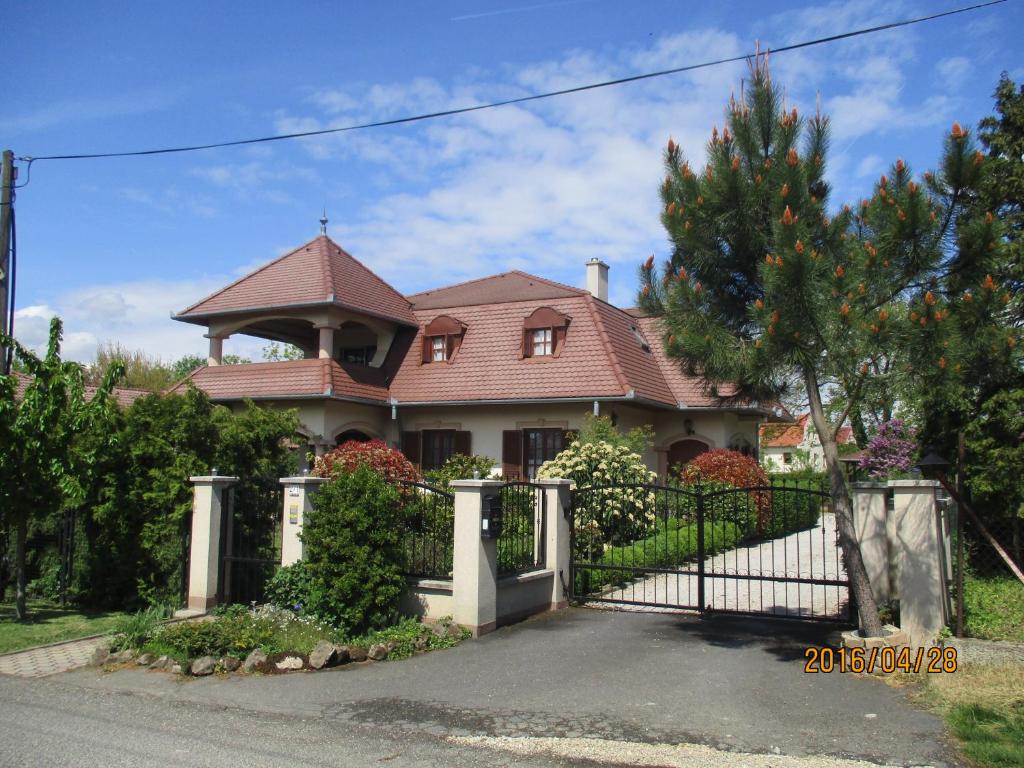 uma casa com um portão em frente em Fodor Ház em Gyenesdiás